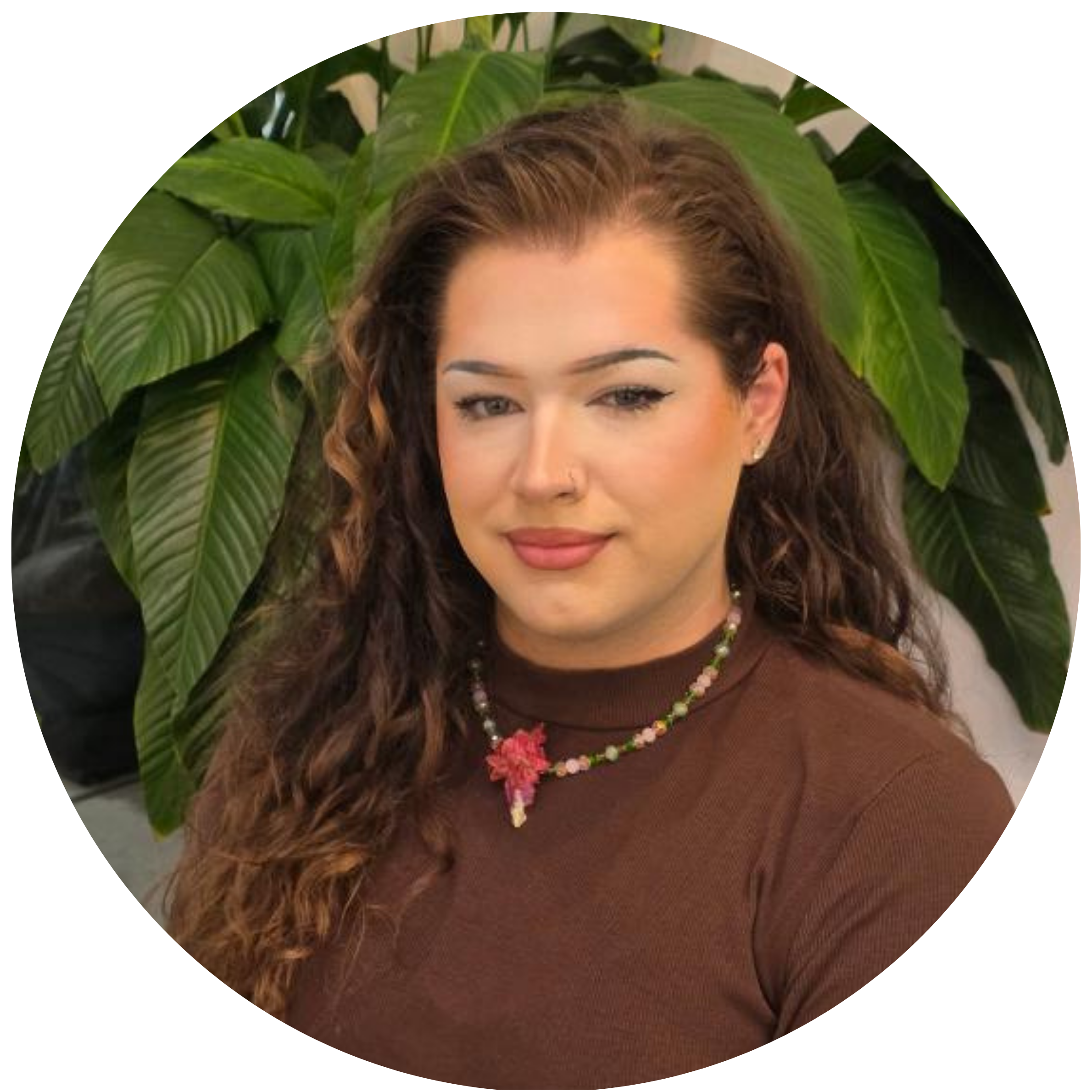 Taylor Vickers sitting in front of a plant at Infinite Salon in Portland, OR